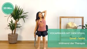 Eine Yogalehrerin zeigt eine Asana für Brustkrebs auf dem Stuhl